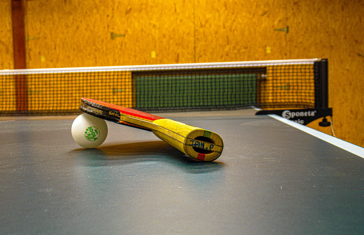 теннисная ракетка и шарик на столе